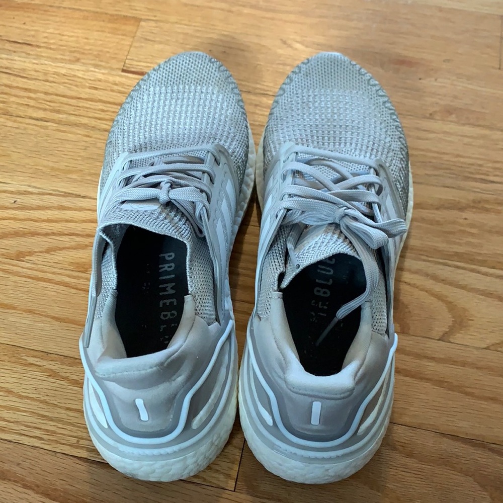 Women’s gray and white Adidas athletic shoes.
